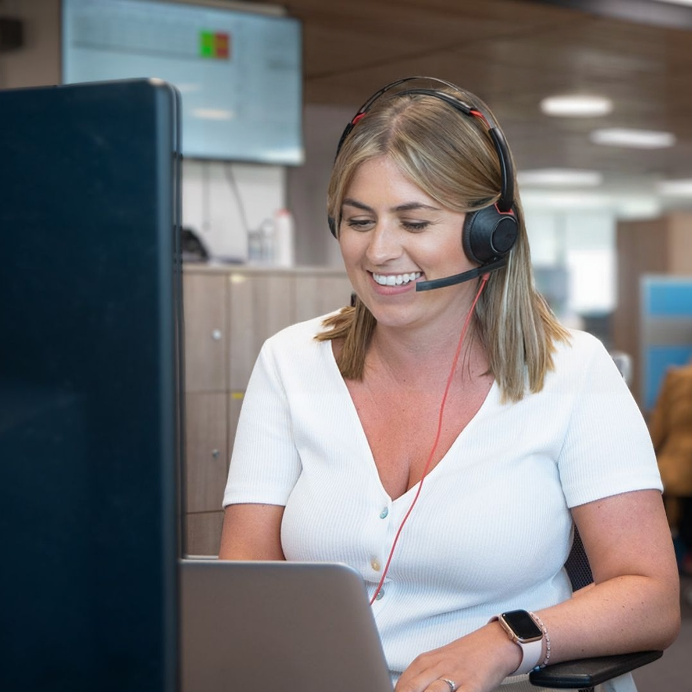 A female adviser sat at a desk having a conversation with a client on the computer