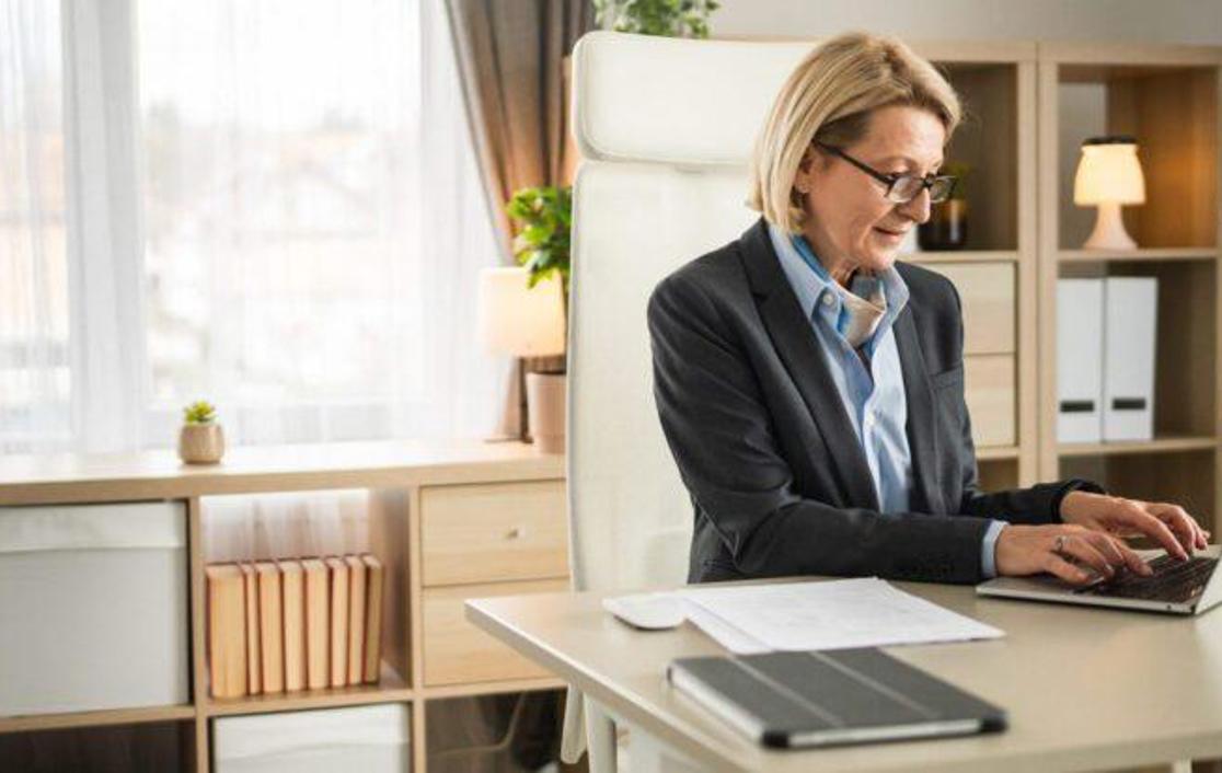 Solo woman stood at her counter working on her laptop