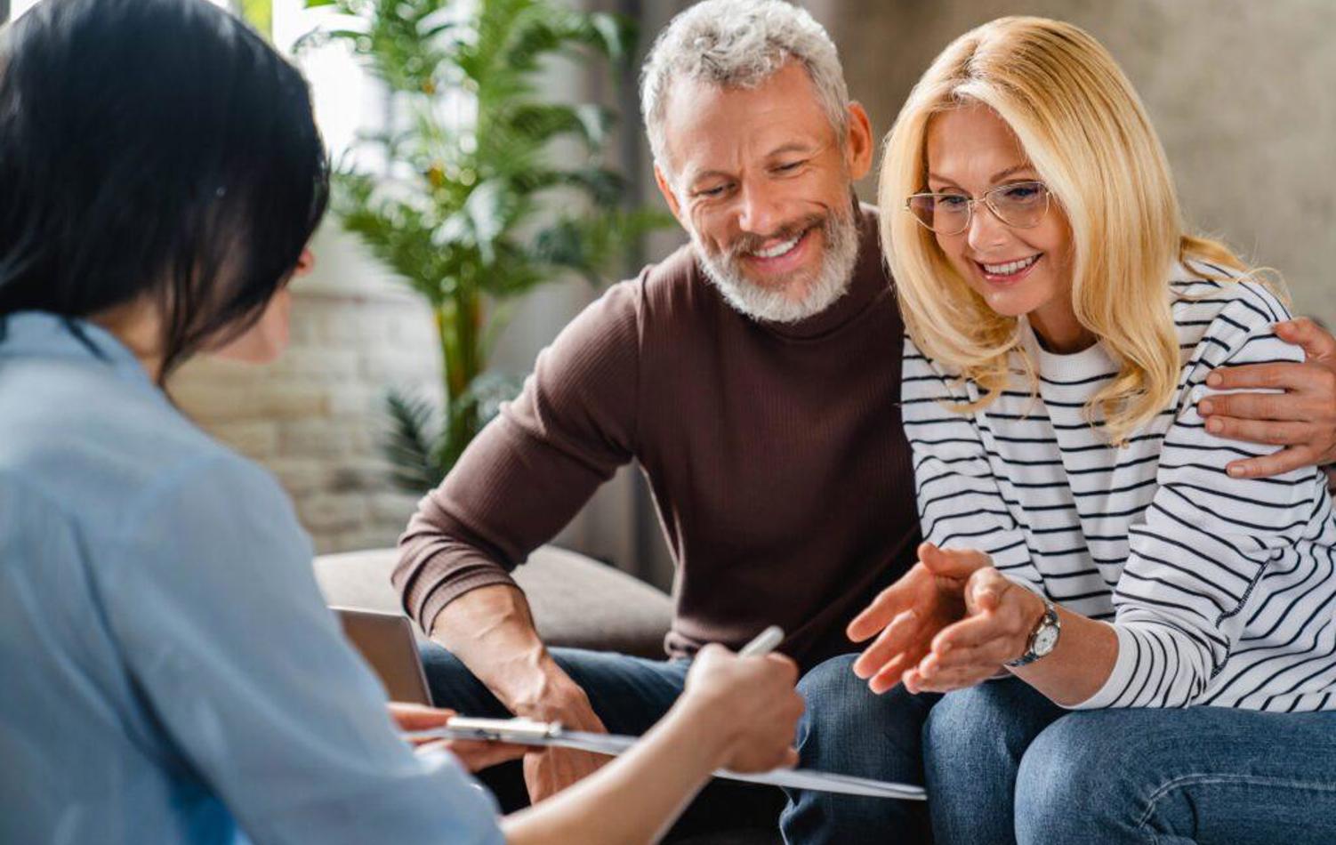 A couple looking over information with a female adviser