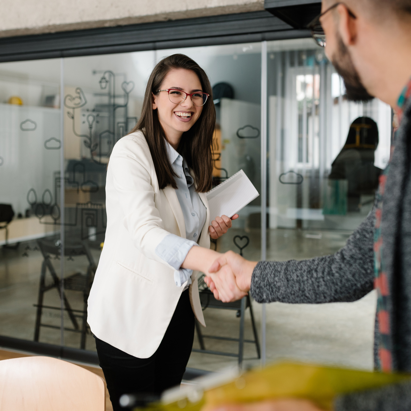 A woman shaking hands with a man smiling