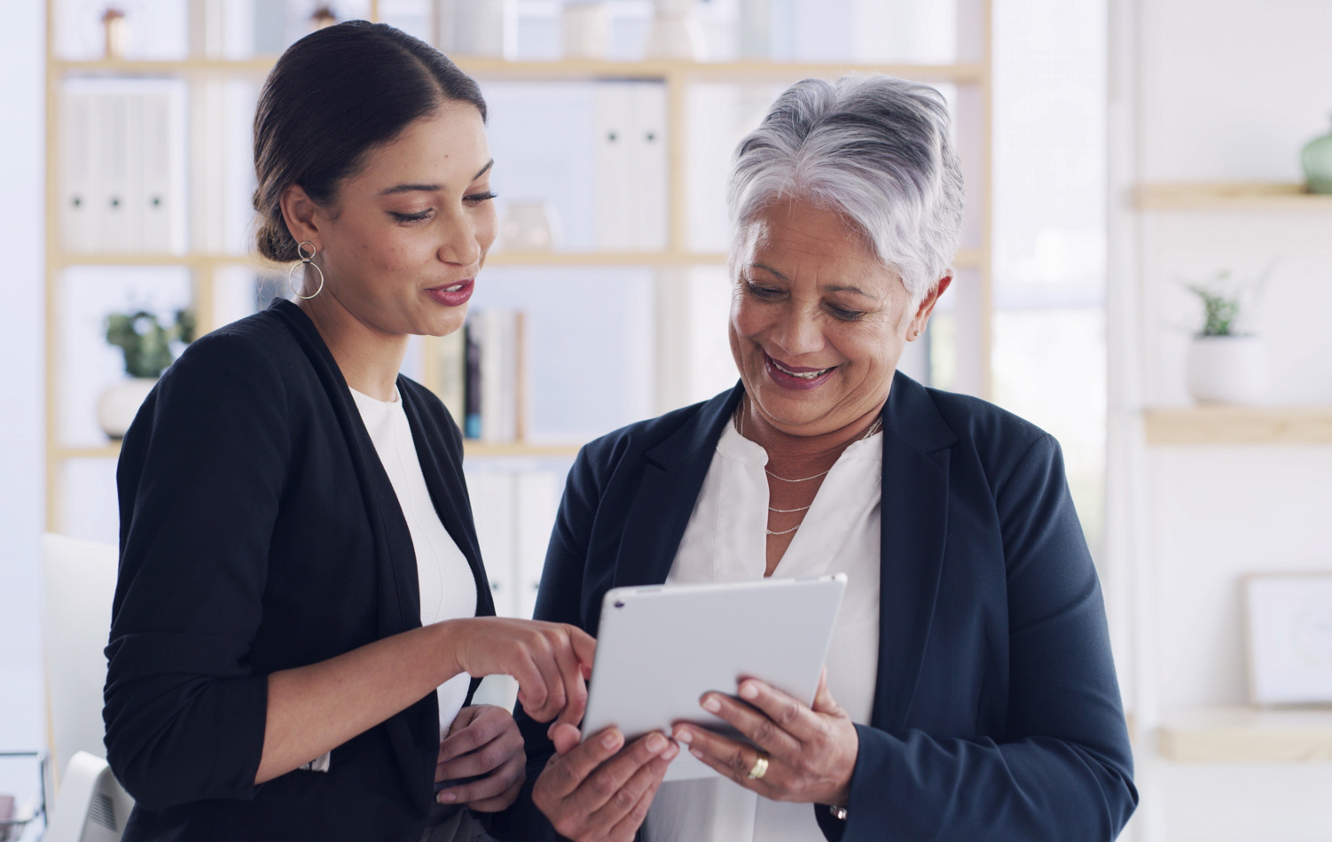 two business women discussing looking at a tablet 